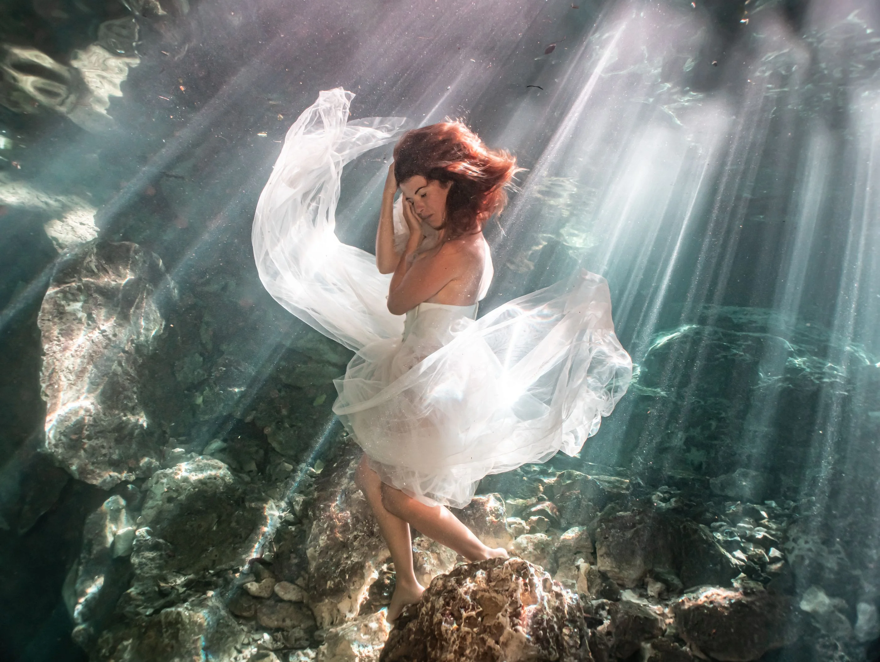 Marina San Martín in a shaft of light, wrapped in white tulle