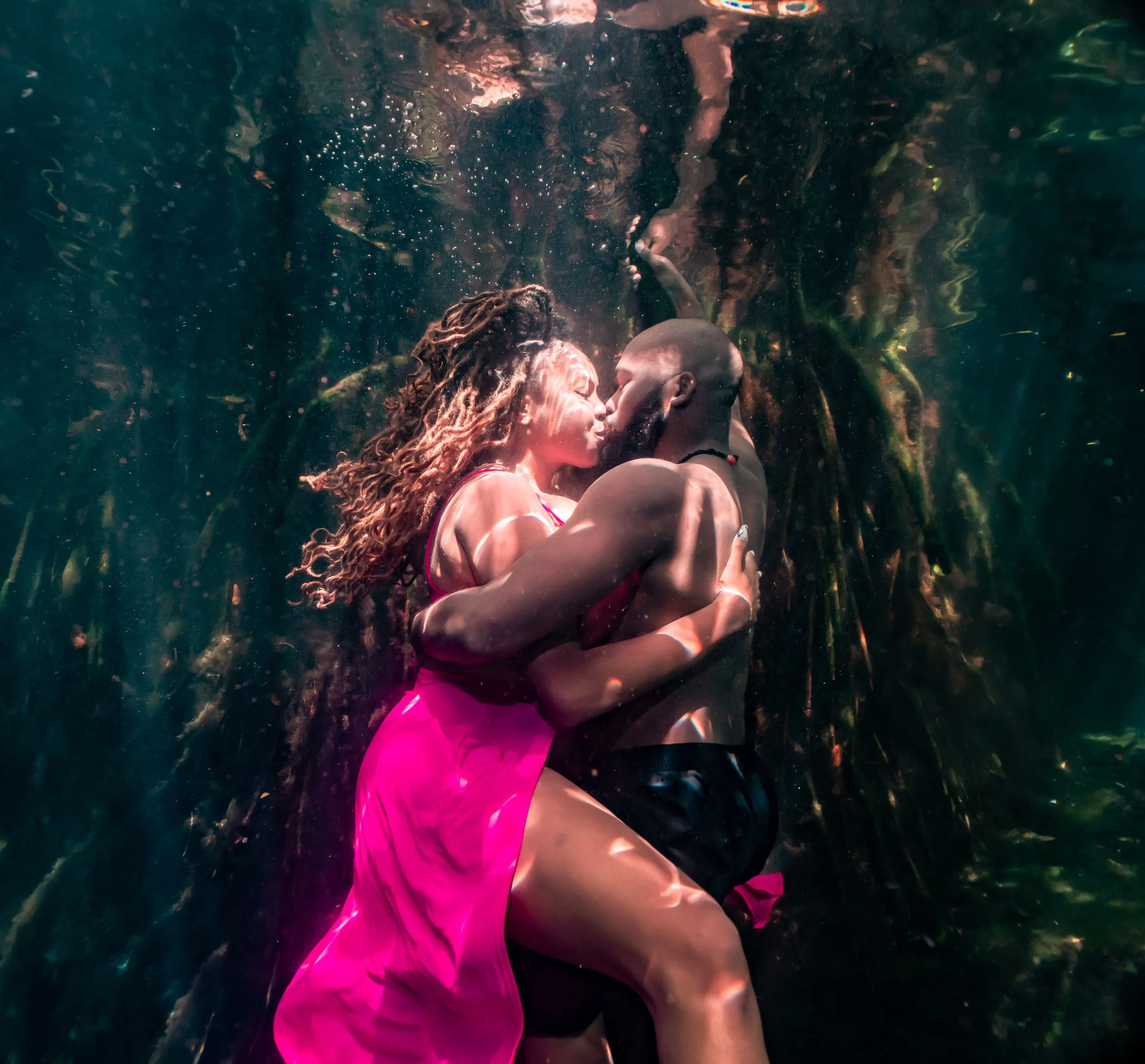 Two figures meeting beneath the surface of a cenote